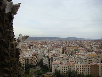 Aerial view of buildings in city against sky