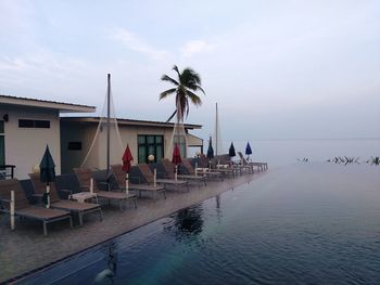 Swimming pool by sea against sky