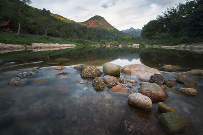 Rocks in lake against sky