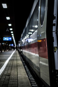 Train at railroad station platform at night