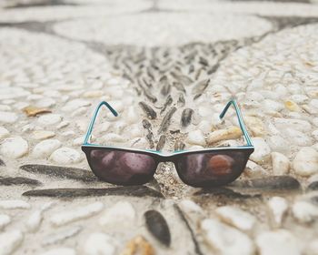 Close-up of sunglasses on sand