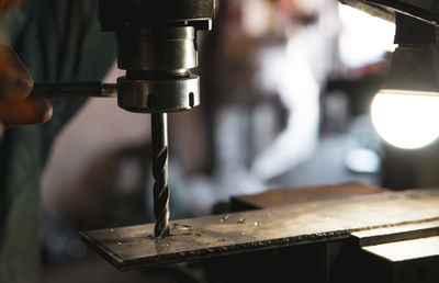 Worker hand working on milling machine to change metal drill bit. tool for drilling metal workpiece.