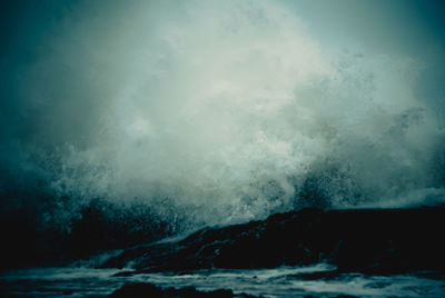 Sea waves splashing against sky