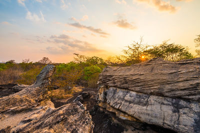 Rock formation on land against sky during sunset