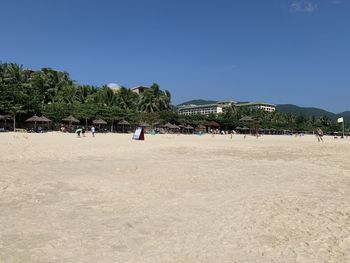 People on beach against clear sky