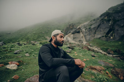 Young man sitting on mountain