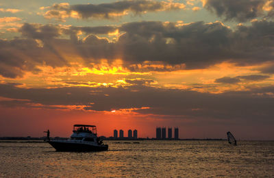 Boat on sea against sky during sunset