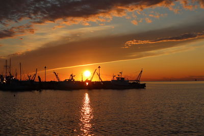 Silhouette sailboat on sea against sky during sunset