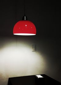 Low angle view of illuminated pendant light hanging on wall