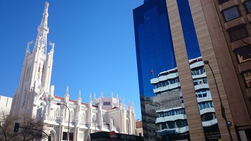 Low angle view of buildings against clear blue sky