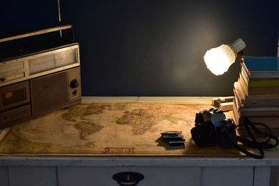 Retro workspace concept. vintage radio and cassette player, old camera, stack of books and world map