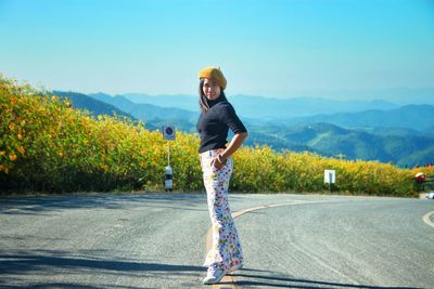 Man standing on road by mountain against sky