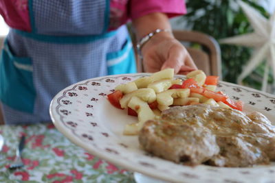 Close-up of man preparing food in plate