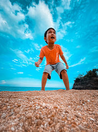Full length of boy at beach against sky