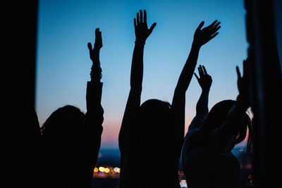 Silhouette hand against sky at night