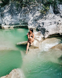 Young couple on rock in water