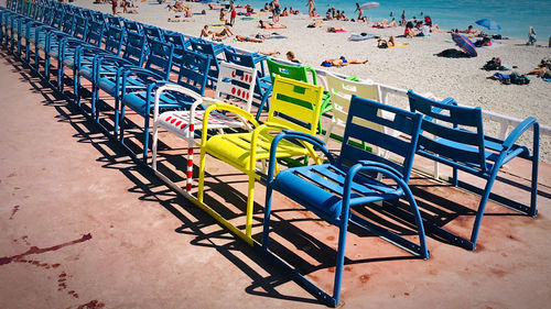 High angle view of empty chairs on beach