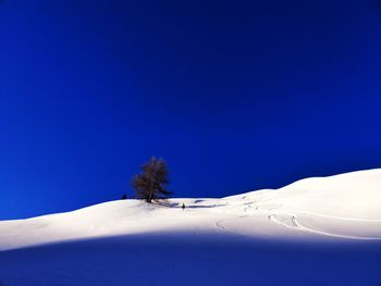 Scenic view of snow covered landscape against clear blue sky