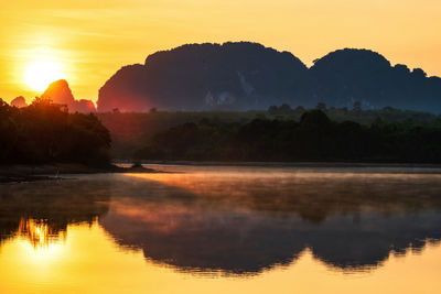 Scenic view of lake against sky during sunrise. nong thale