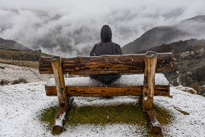 Woman sitted on a bench in a snowy day