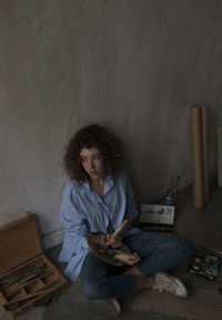 Young woman sitting on book at home