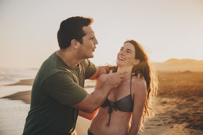 Side view portrait  of young couple at beach