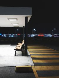 Man crossing road against illuminated city at night