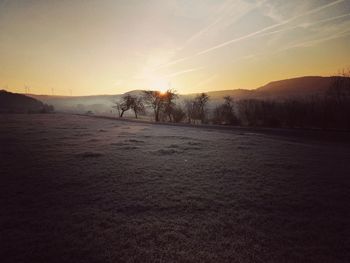 Scenic view of field against sky during sunset