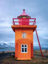 Orange lighthouse in eyjafjörður fjord in northern iceland in winter near the town of akureyri