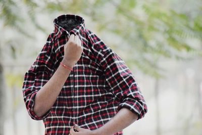 Man with face covered by shirt