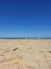 Scenic view of beach against clear blue sky