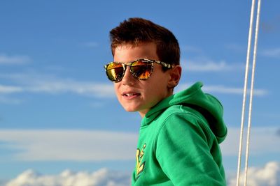 Low angle view of boy against blue sky