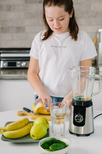 Portrait of young woman having food at home