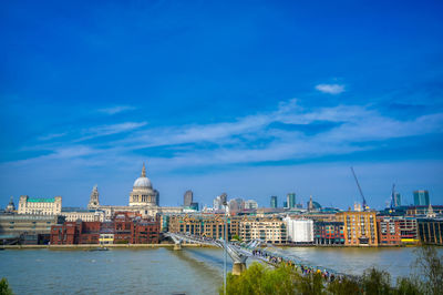 River amidst buildings against blue sky