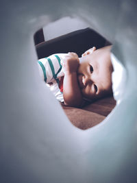 Portrait of cute boy lying on bed