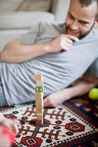 Midsection of man sitting on bed at home