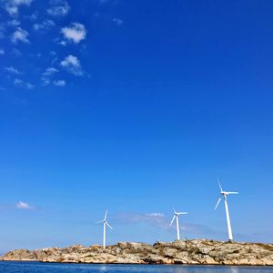 Wind turbines on land against sky