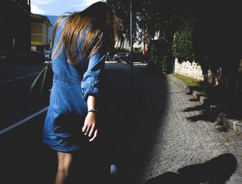 Rear view of young man walking on road