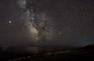 Scenic view of sea against star field at night