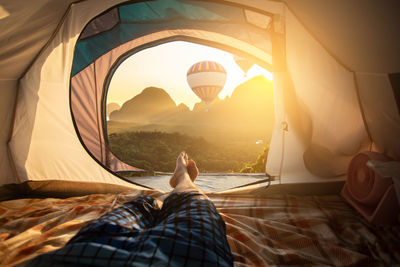 Low section of man lying in tent against parachute