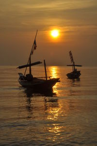 Two boats on sea against sky during sunset