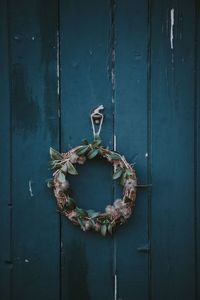 Close-up of wreath hanging on wood paneling