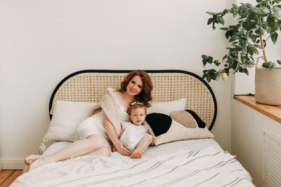 Portrait of a smiling young woman lying on bed