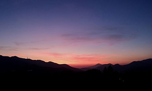 Scenic view of silhouette mountains against sky at sunset