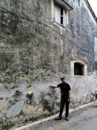 Full length of man standing by building in city