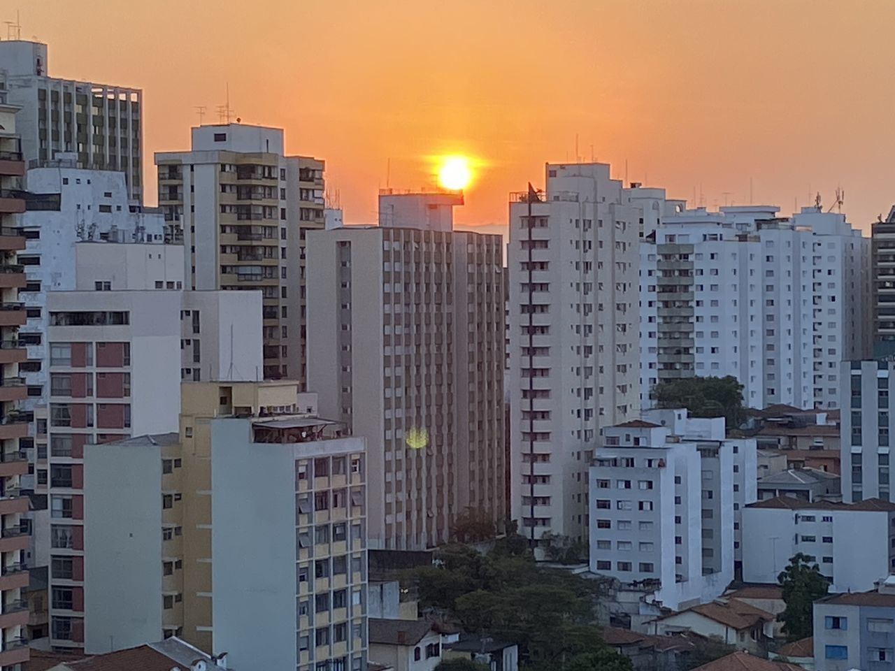 HIGH ANGLE VIEW OF BUILDINGS AGAINST SKY AT SUNSET