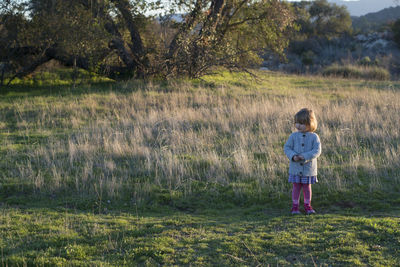 Rear view of girl standing on field