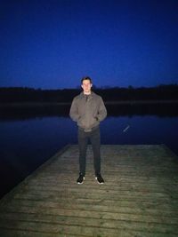 Full length portrait of man standing in lake against clear sky