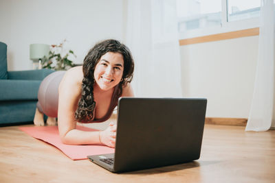 Young smiling woman exercising at home