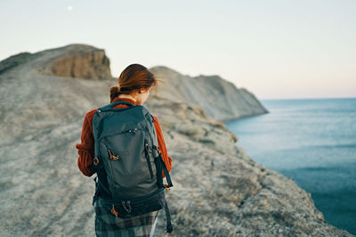 Rear view of man looking at sea against sky